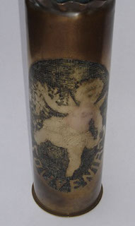 Shell depicting a playful Cupid in a medallion including word SOUVENIR, surrounded by a garland of flowers. Blackened background.