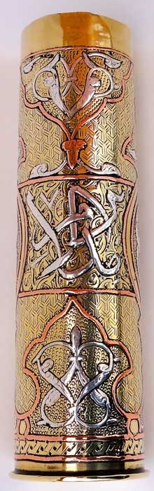 Shell of small caliber (37mm) with intricate ornemental patterns inlaid in copper and silver. 