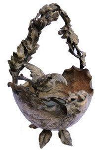Metal basket with intertwined branches for handle. Bird ready to fly, perched on the wing. Upside down structure of a helmet.