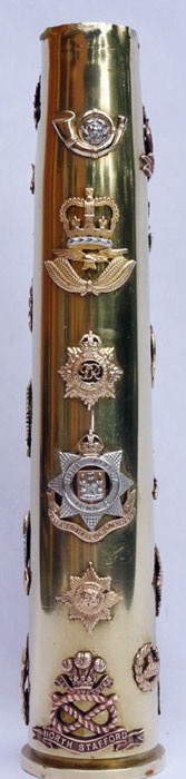 Shell with three sets of six British army cap badges soldered on a 40mm Bofors dated 1944.