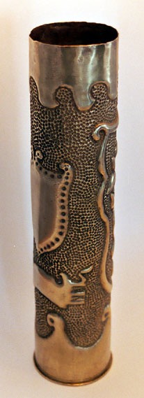 Shell with shield from the Middle-Ages with edges of dots, banner below.