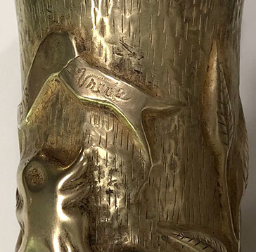 Shell with a long ribbon with Orlog [war] 1914-15-16-17-1918 Vrede [peace]. Leafy branch on a dashed background.