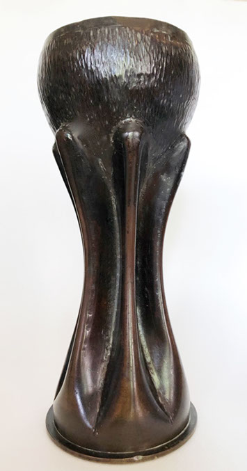 Six sturdy flutes hold an opened bowl.