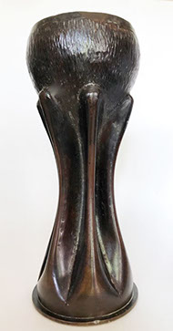 Six sturdy flutes hold an opened bowl.