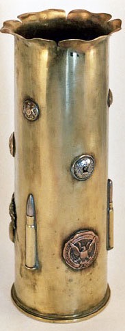 Shell soldered with cap badges, buttons and cartridges from England, France and the US.