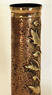 Shel with an oak branch with acorns embossed on a stippled background. Top and bottom slightly&nbsp; flared.